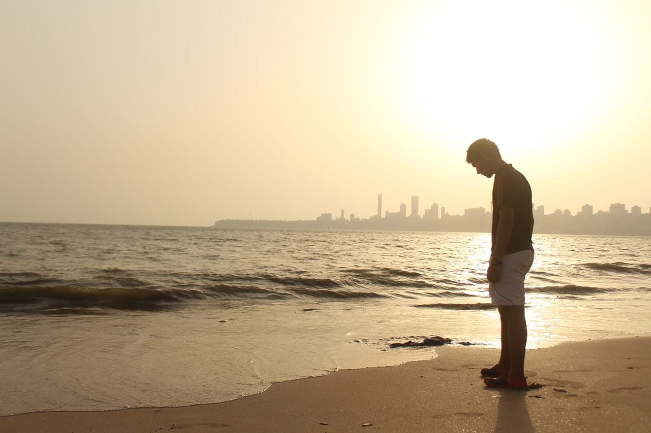 Hình hình ảnh chàng trai buồn đứng trước bến bãi biển